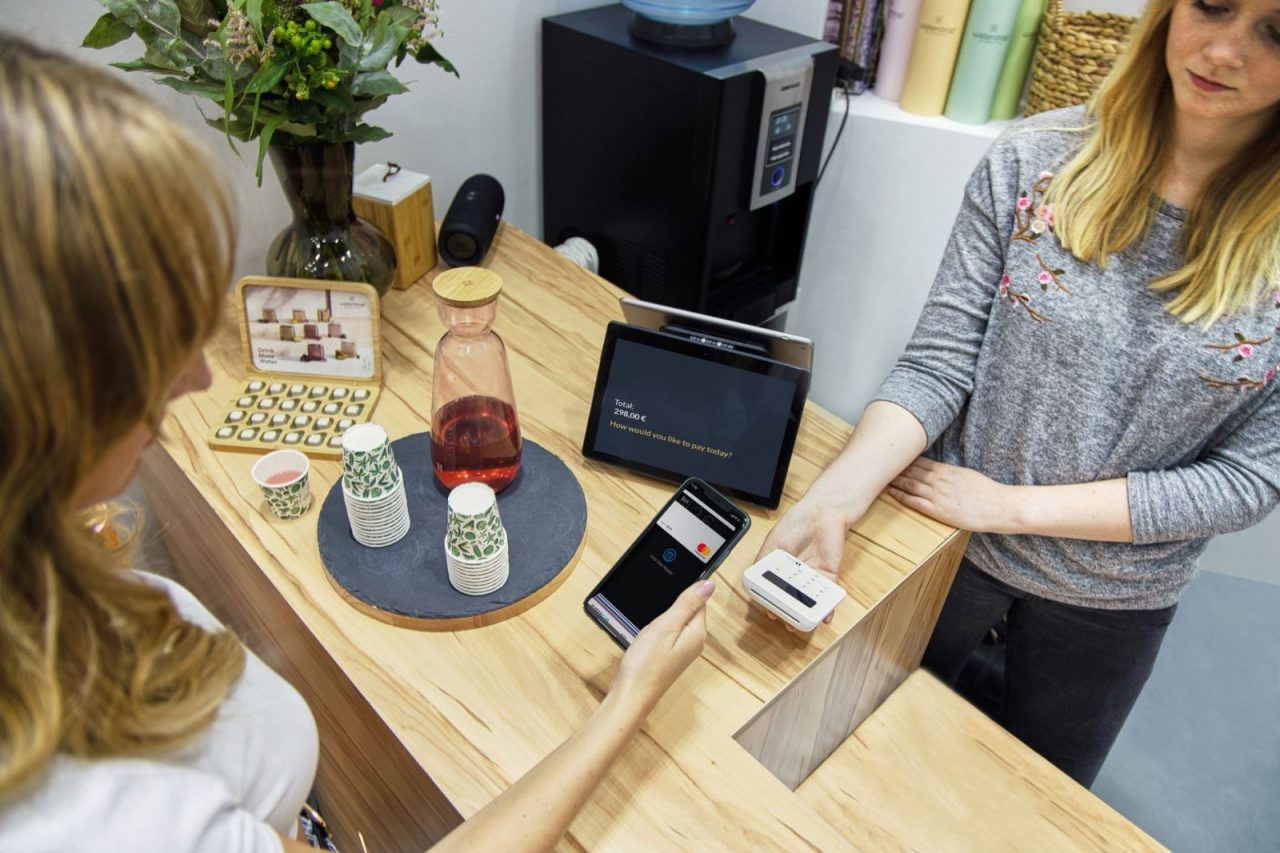 Une femme effectue un paiement sans contact dans un café berlinois moderne