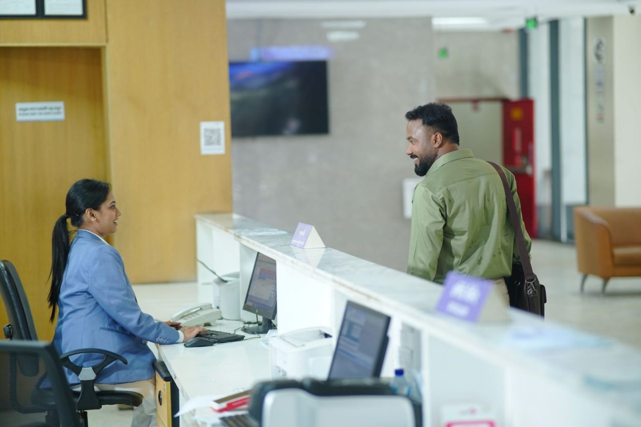 Receptionist assisting a guest at a hotel desk in Dhaka, Bangladesh