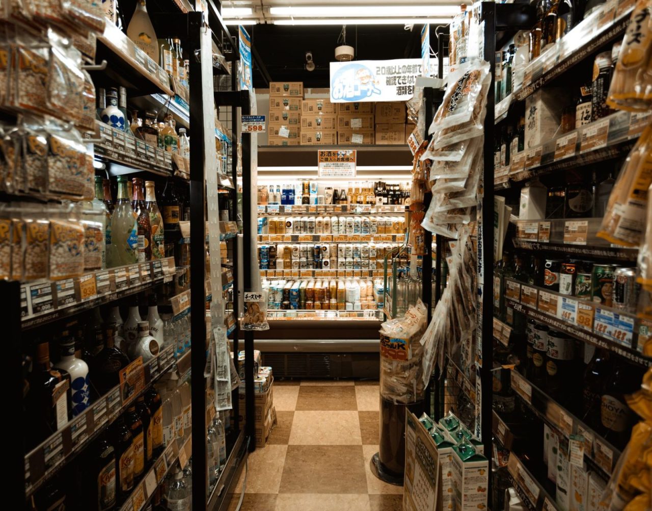 Busy Tokyo convenience store aisle filled with various products and merchandise