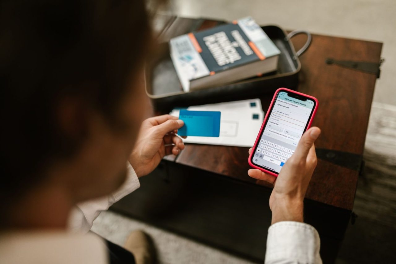 Person completing an online payment using a smartphone and credit card