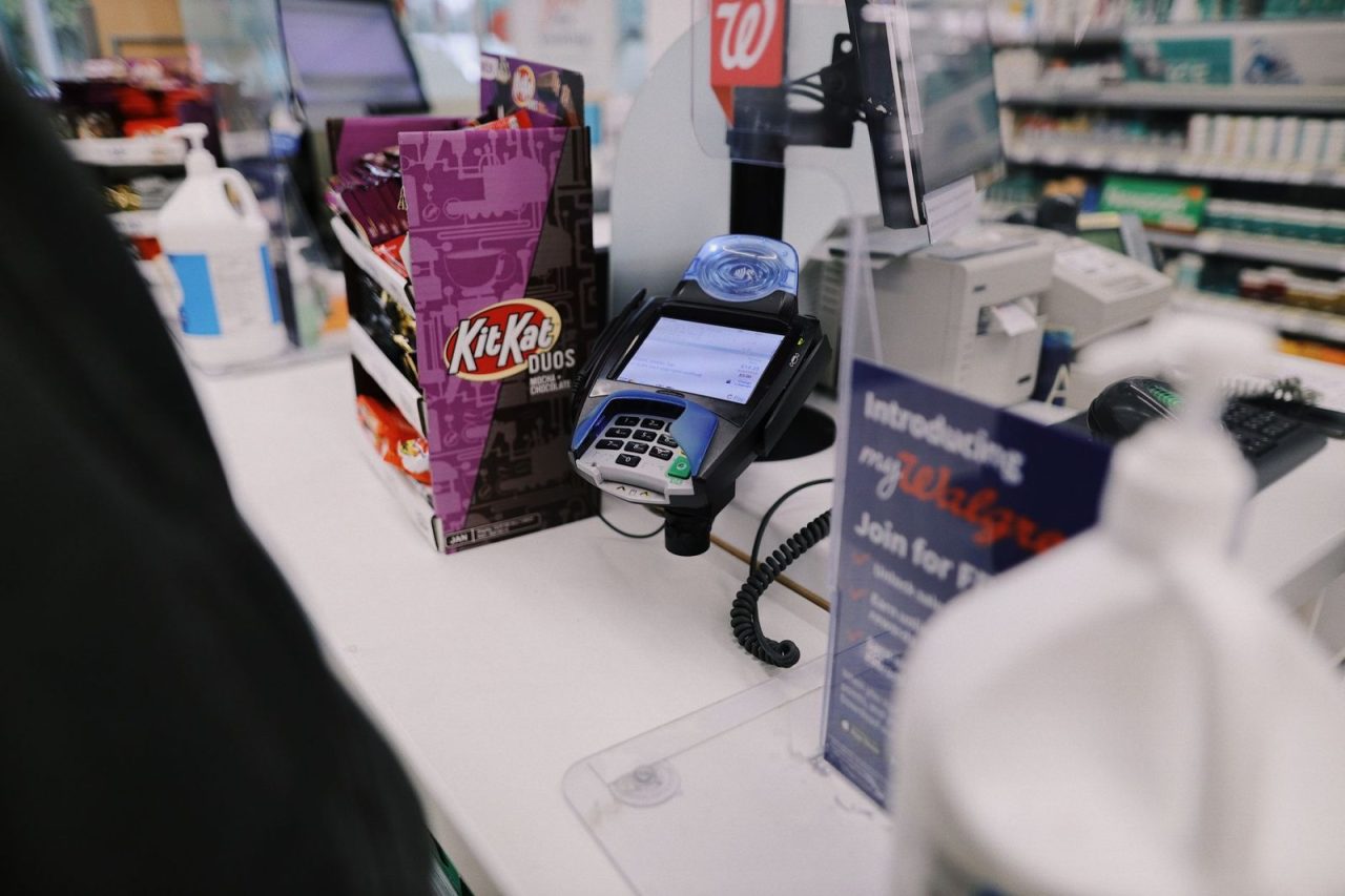 Retail checkout counter with a credit card reader and various goods