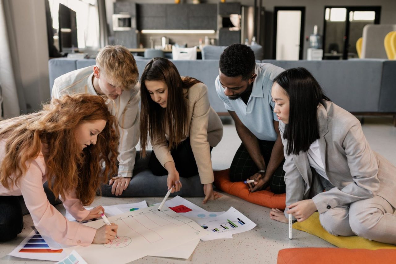 Young professionals collaborating indoors with charts during a project meeting
