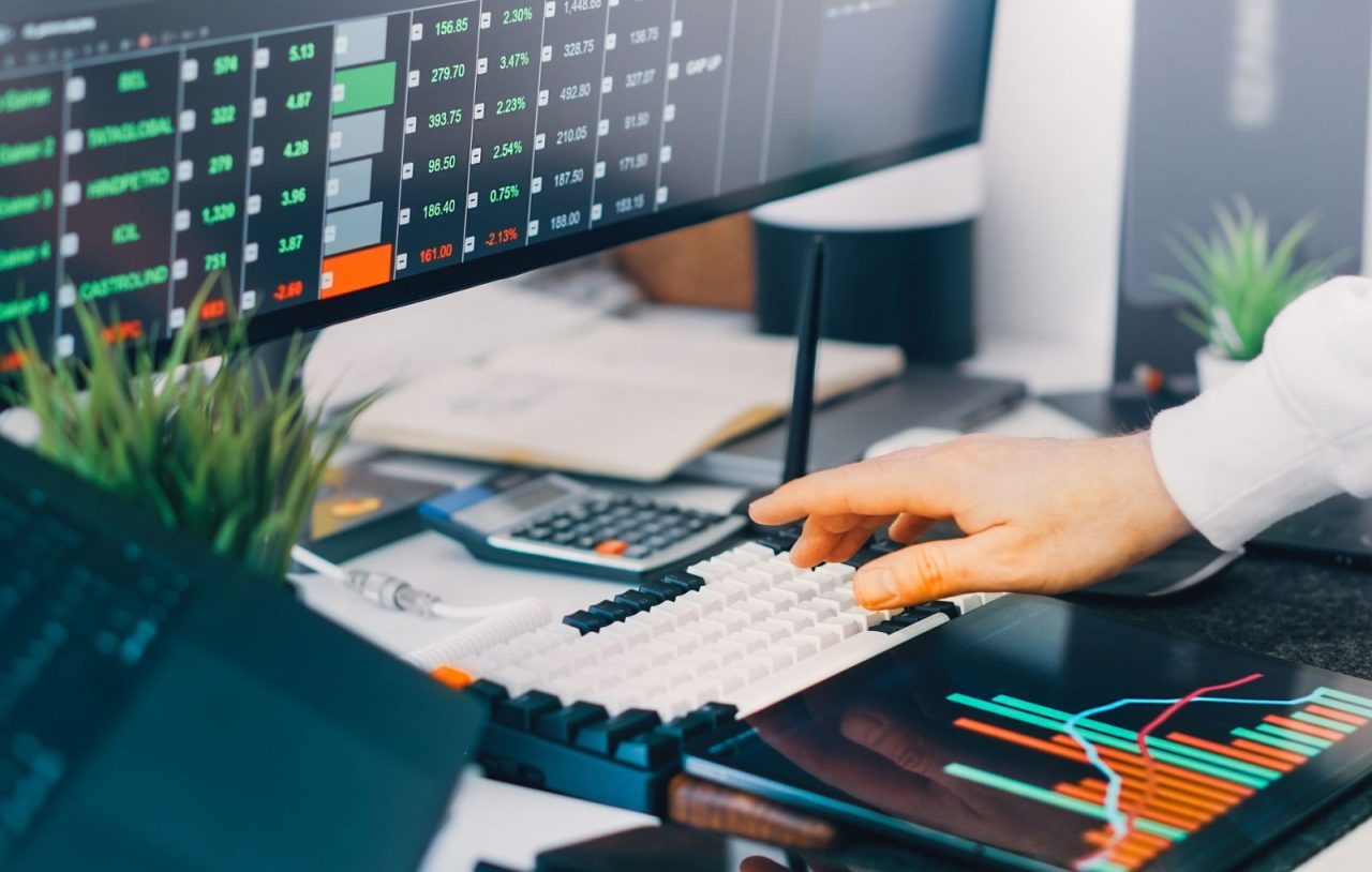Workspace with trading charts and market data on laptop screens