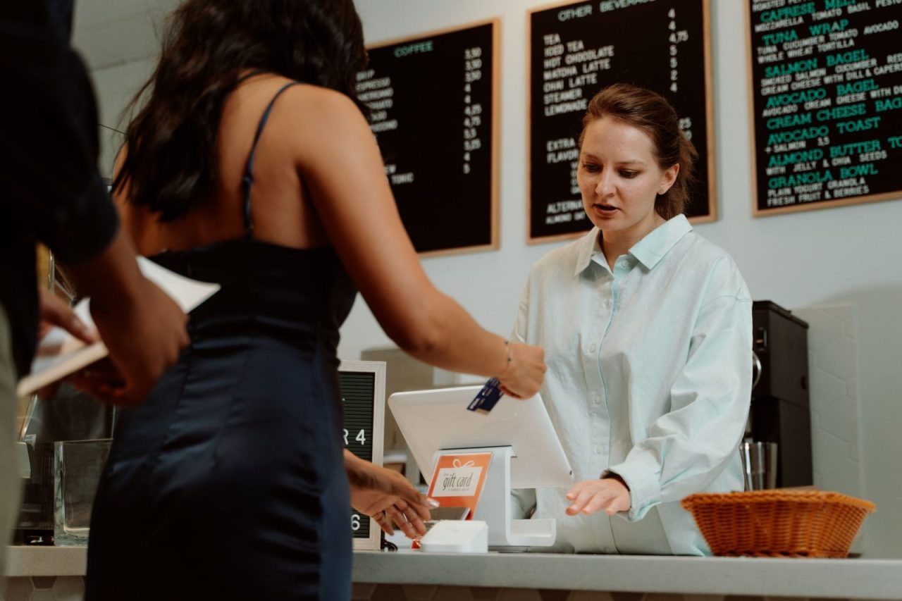 Client payant par carte à un café avec l'aide d'un barista