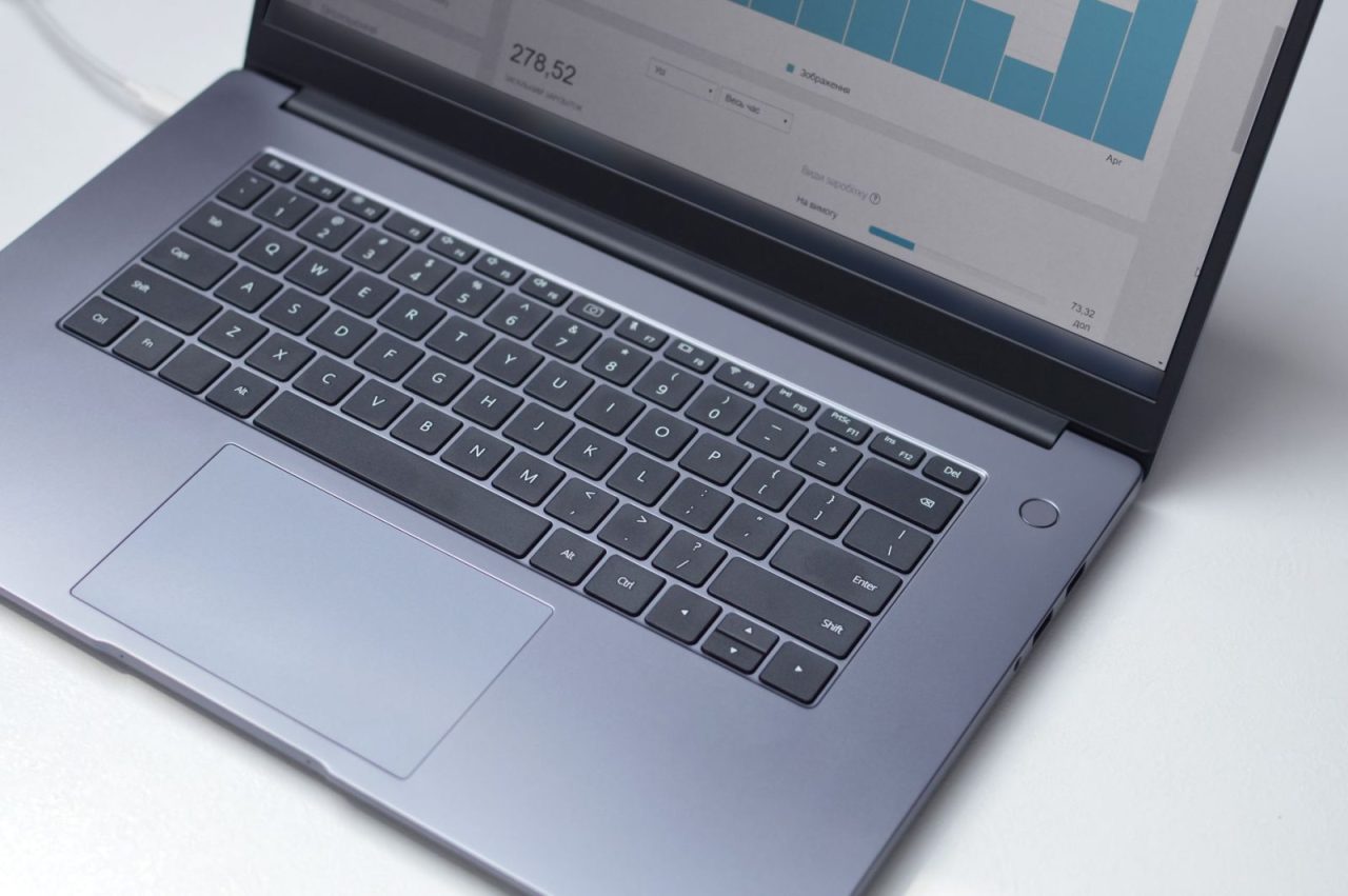 Laptop viewed from above displaying an analytics dashboard on a white table