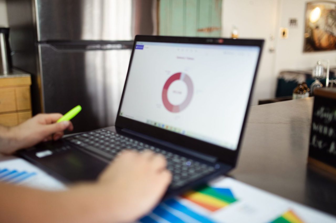 Person reviews business analytics and product images on a laptop indoors