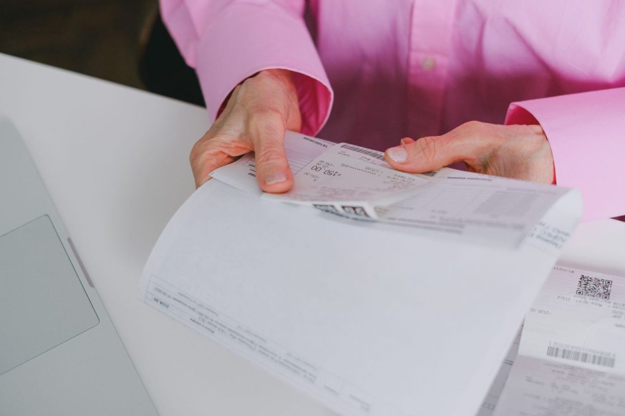 Business person sorting and reviewing organized paper receipts