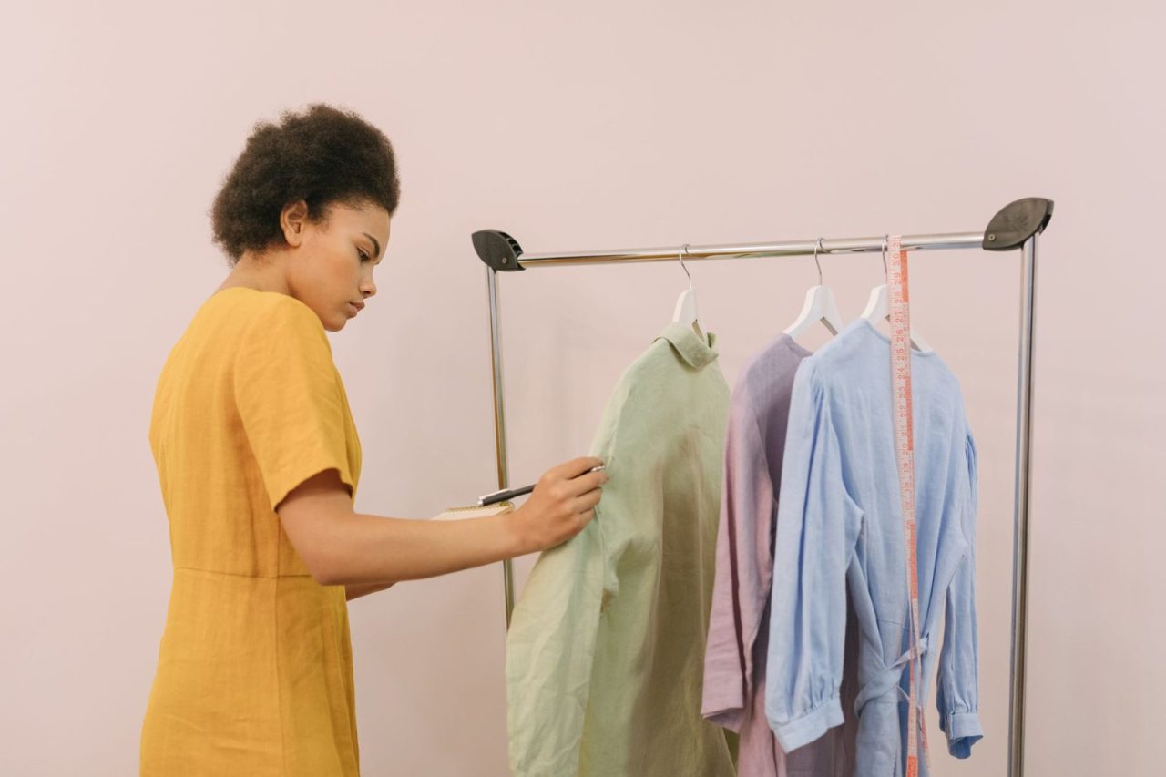 Woman reviewing clothing inventory on a rack in a boutique