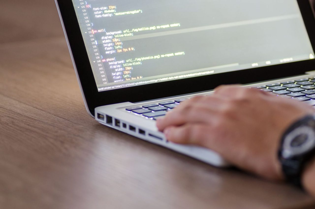 Laptop screen displaying HTML code as a developer works on customization