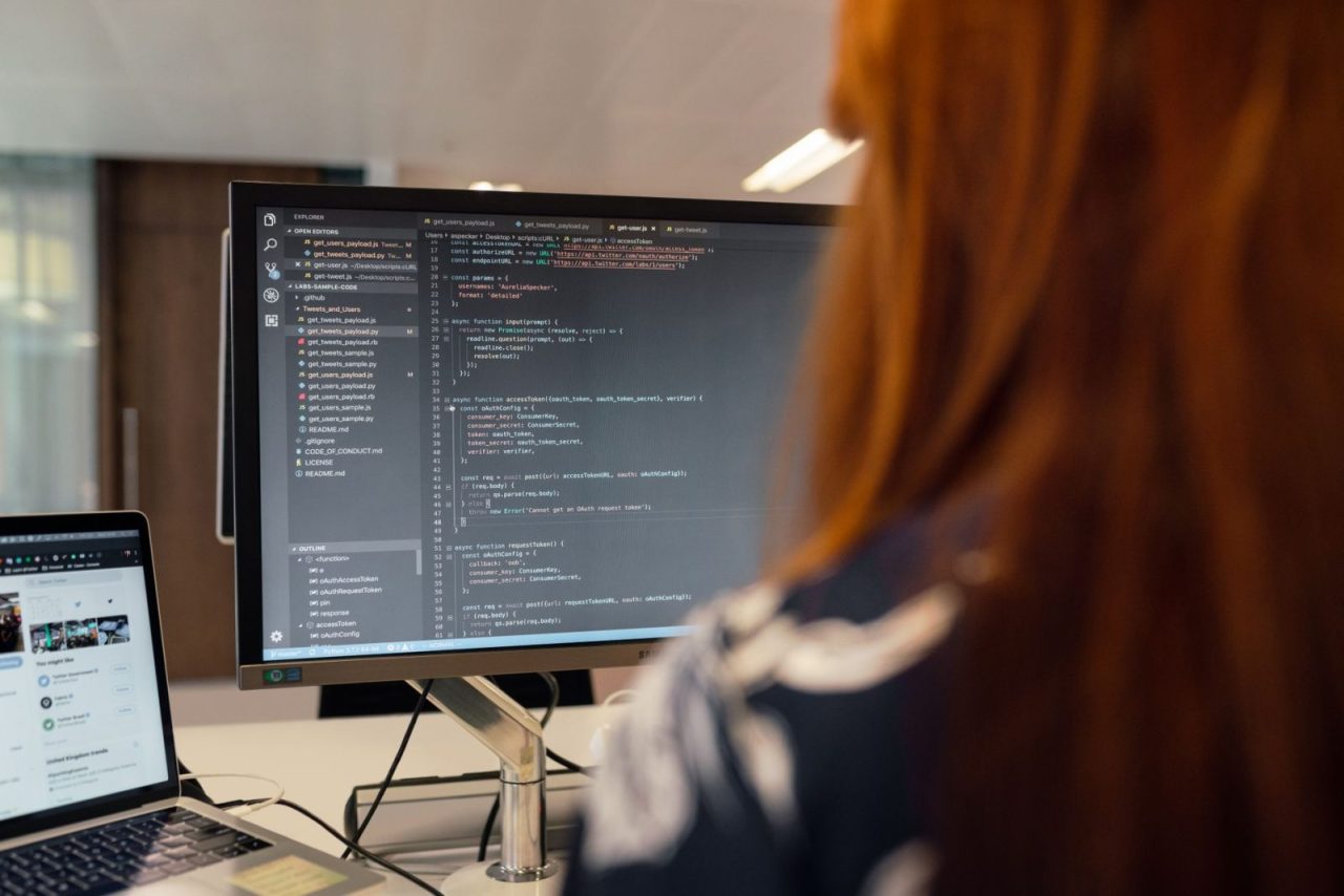 Engineer writing code at a desk in a modern office environment