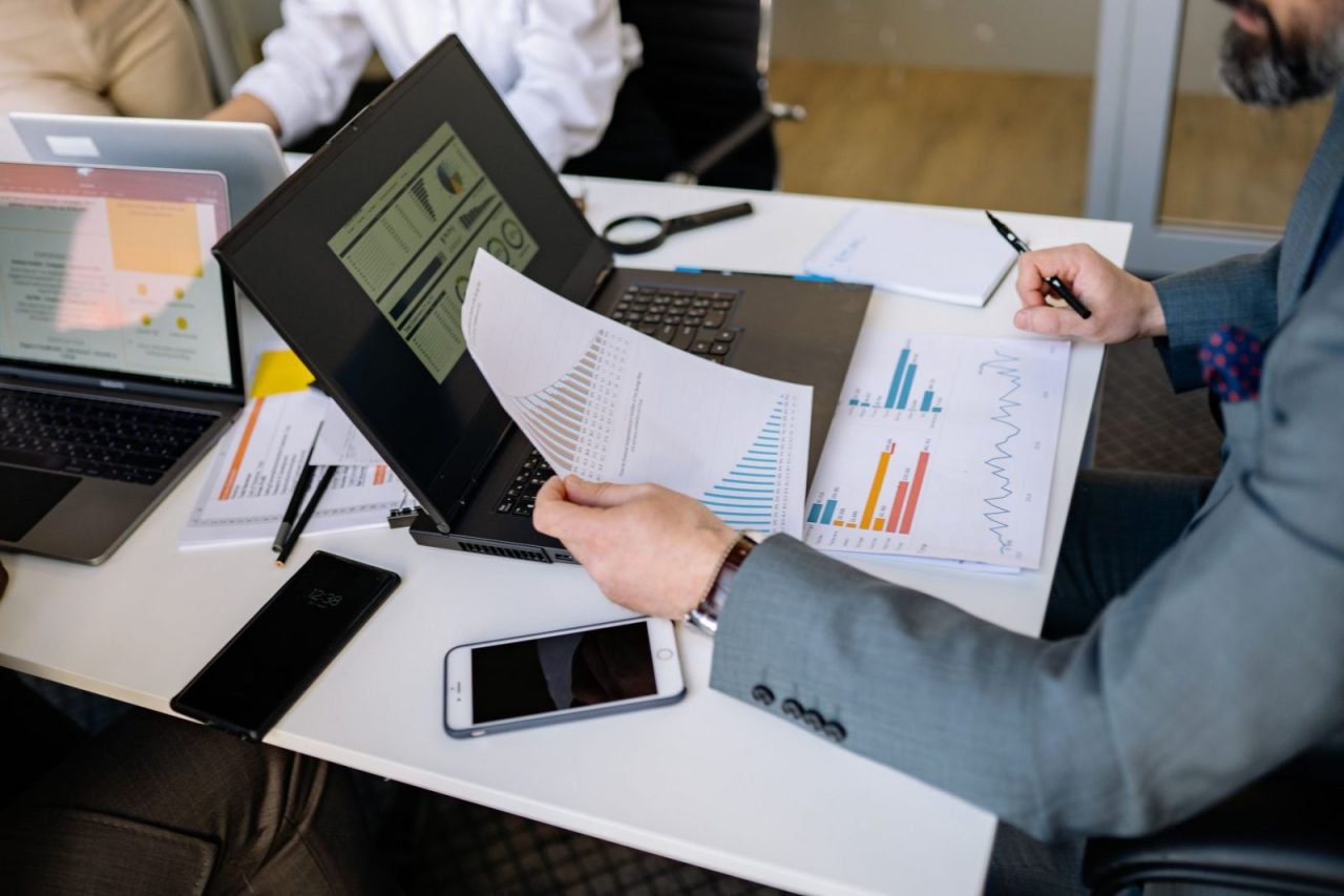 Team reviewing charts and graphs on laptops during a meeting